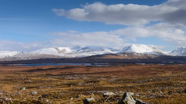 Scottish highlands scenery. Moving clouds casts shadows on ground. Time lapse, pan from left to right.