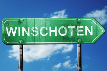 Winschoten road sign, vintage green with clouds background