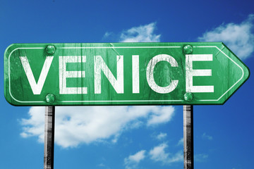 Venice road sign, vintage green with clouds background