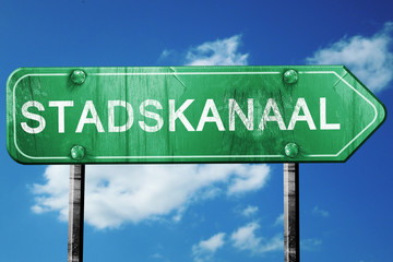 Stadskanaal road sign, vintage green with clouds background