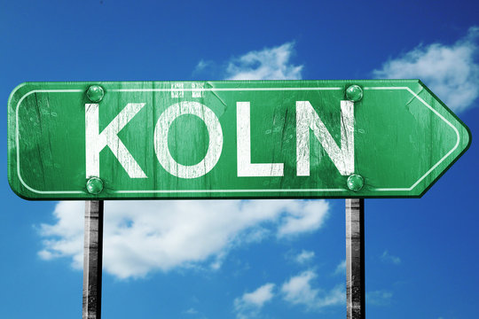 Koln road sign, vintage green with clouds background