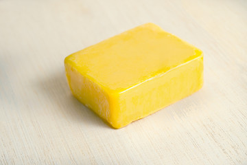 Soap bar flavor with mango ingredient isolated on wooden board b