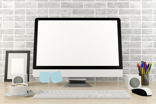 Isolated computer display for mockup in office interior. Working desk with keyboard, mouse, speaker, cup of coffee, pencils, frame