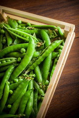 Peas group in wooden box on dark wooden table