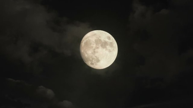 Timelapse with zooming moon and clouds. Night, full moon, dark clouds.