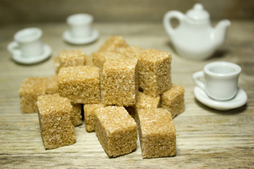 Cubes brown cane sugar on wooden background