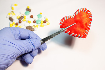 Red heart in the hands of the doctor on a white background