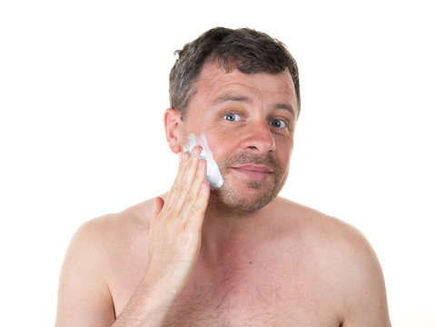 Cheerful man in his bathroom shaving in the morning