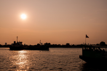 Fototapeta premium Silhouette,blurry boat on the river at sunset.art tone background.
