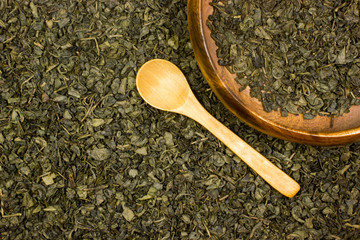 Green dry tea and wooden spoon