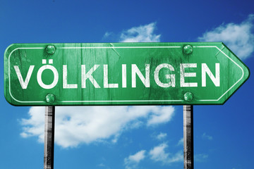 Volklingen road sign, vintage green with clouds background