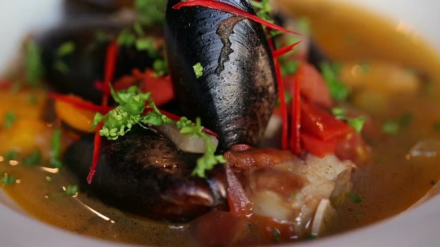 Soup with mussels beautiful dish. Plate rotates.