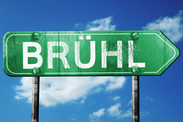 Bruhl road sign, vintage green with clouds background