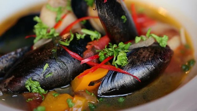 Soup with mussels beautiful dish. Plate rotates.