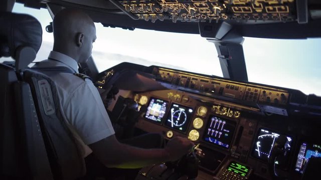 Dramatic angle from rear of 747 cockpit as African American pilot banks the plane over an area of northern California, USA.   Stabilized hand-held camera, originally recorded in 4K at 30ps.