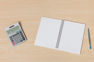 notebook, pen and calculator on wood