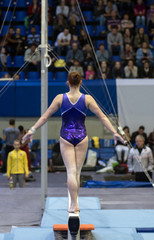 Gymnastics. Gymnast doing a exercise on the Balance Beam. View from the back.