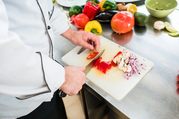 Chef cutting onions and vegetable to prepare for cooking