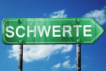 Schwerte road sign, vintage green with clouds background