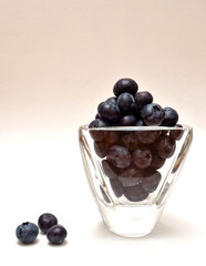 Blueberries in a glass on a white background