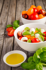 Italian Caprese salad with cherry tomatoes, small mozzarella and fresh basil, selective focus, copy space