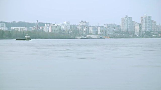 Time lapse of barge moving on Dnieper river with view on Vyshgorod, Kiev oblast, Ukraine, on background of apartment blocks. Shot in spring 2016