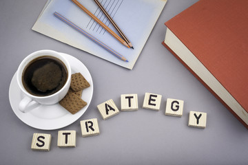 Text: Strategy from wooden letters on a gray desk