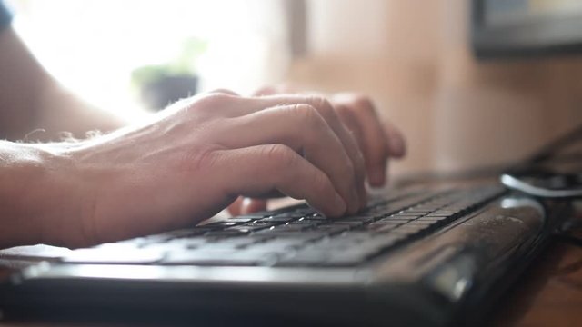 Man hands touch typing quickly on black keyboard