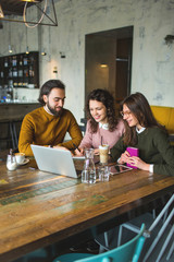 Yong hipster male and females in cafe working with laptop