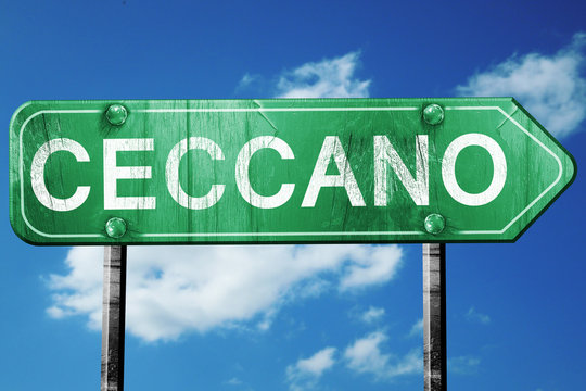 Ceccano road sign, vintage green with clouds background