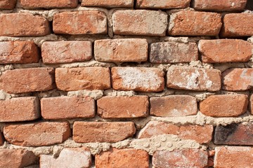 The old crumbling brick wall. Bricks and stones in the old wall. The old brick wall collapses and urgent repair is necessary
