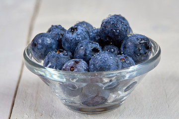 Fresh blueberries with water drops in a glass bowl