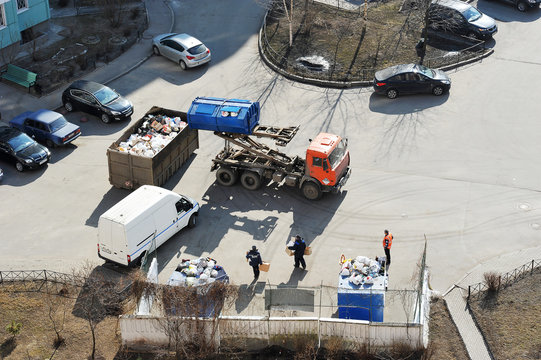 garbage truck collects the trash in the yard of a house - Powered by Adobe