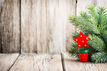 Christmas decoration with fir branches on the wood background.