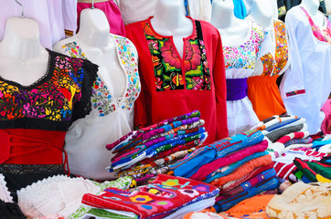 Colorful authentic Mexican women blouses on manikins at the market