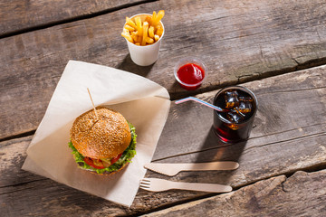 Burger with fries and ketchup. Food with white paper cutlery. Crispy fries and hot hamburger. Charge yourself with energy.