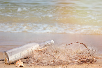 A bottle with a message on the sea beach.