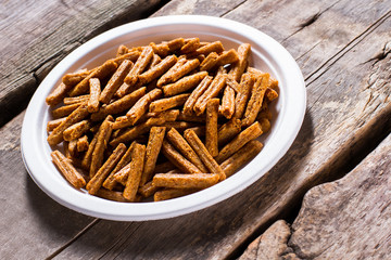Pile of crackers on plate. Brown crackers on old table. Special recipe of homemade crackers. Snack served in local diner.