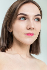 Beauty portrait of young model with middle length hair. Professional nude makeup. Green eyes.