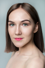 Beauty portrait of young model with middle length hair. Professional nude makeup. Green eyes.