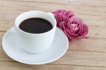 Coffee cup with flower on wooden table