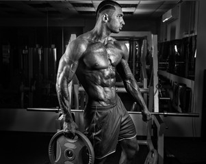 Muscular athletic bodybuilder fitness model posing after exercis