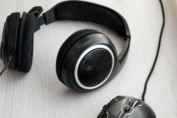 High Angle View of Modern  Audio Headphones with Cord and Mouse on Grey Desk Background with Copy...