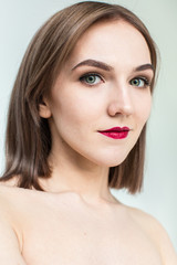 Obraz premium Portrait of gorgeous young caucasian attractive sexy woman with business makeup. Red lips and green eyes