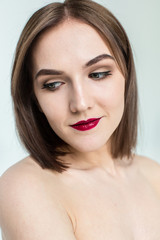 Portrait of gorgeous young caucasian attractive sexy woman with business makeup. Red lips and green eyes