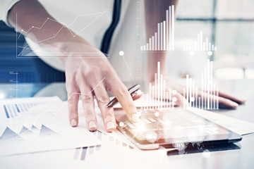 Picture female hand touching modern tablet.Investment manager working new private banking project office.Using electronic device.Graphic icons,worldwide stock exchanges interface on screen. Horizontal