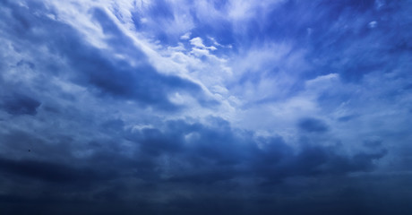 Naklejka na ściany i meble Fluffy rain clouds in a blue sky