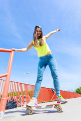 Teen girl skater riding skateboard on street.
