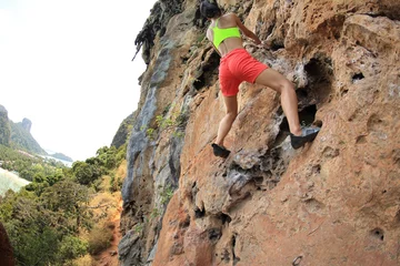 Foto op Canvas young woman rock climber climbing at seaside mountain rock © lzf