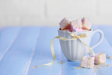 Tasty marshmallows with chocolate in cup on table, close up